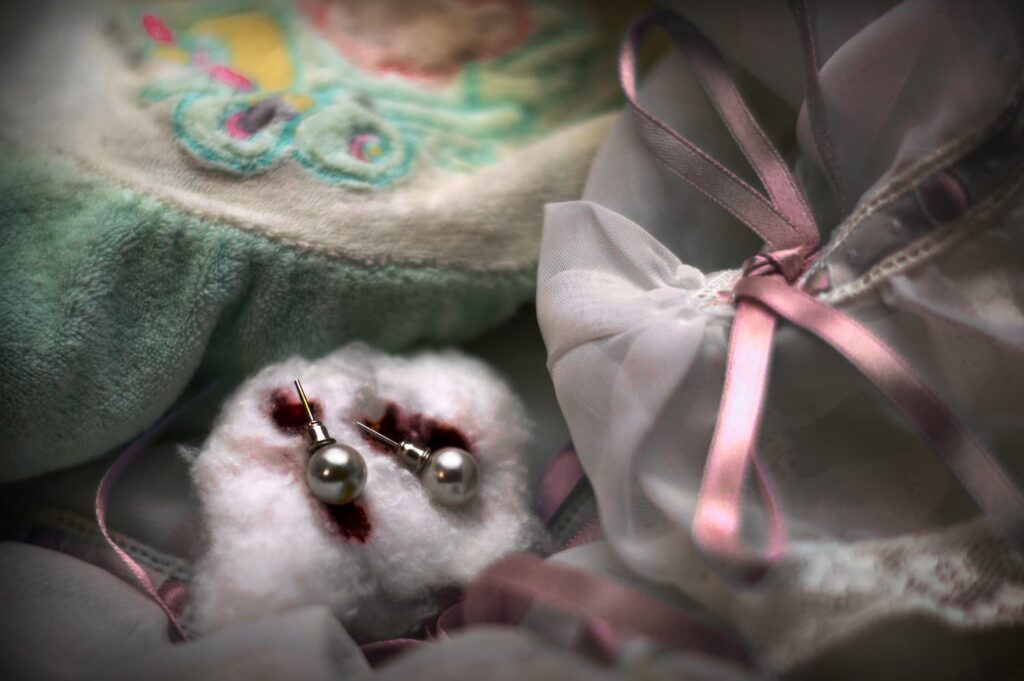 Tetrapack_EsterFdez_01 Pendientes ensangrentados entre femenina ropa de bebé